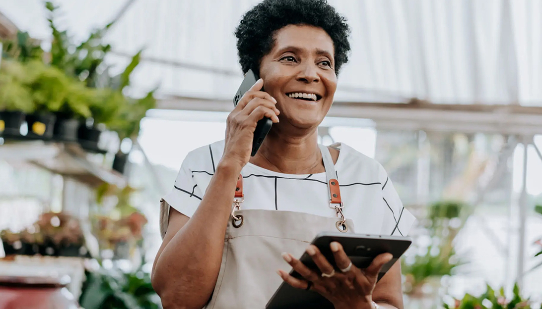 Business owner on phone holding tablet 